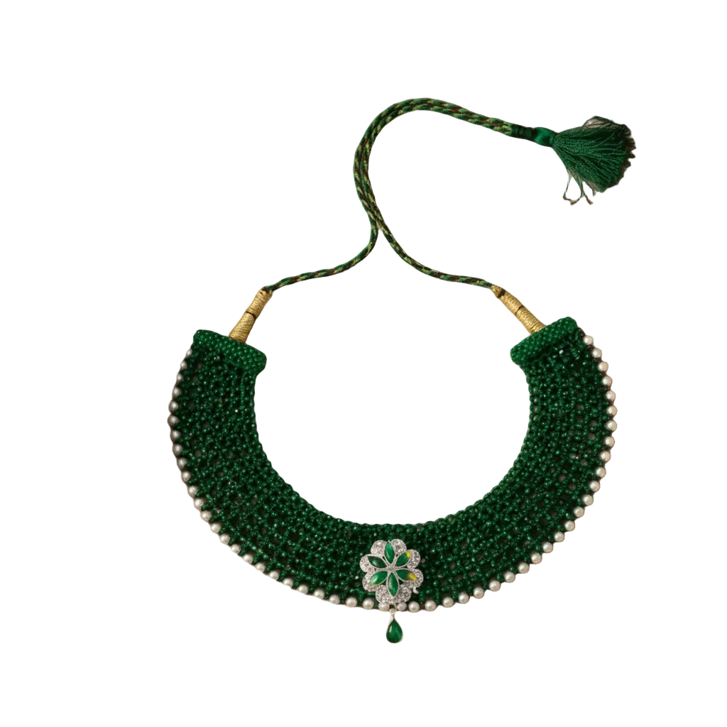 Green beaded necklace with a floral clasp on a beige fabric background